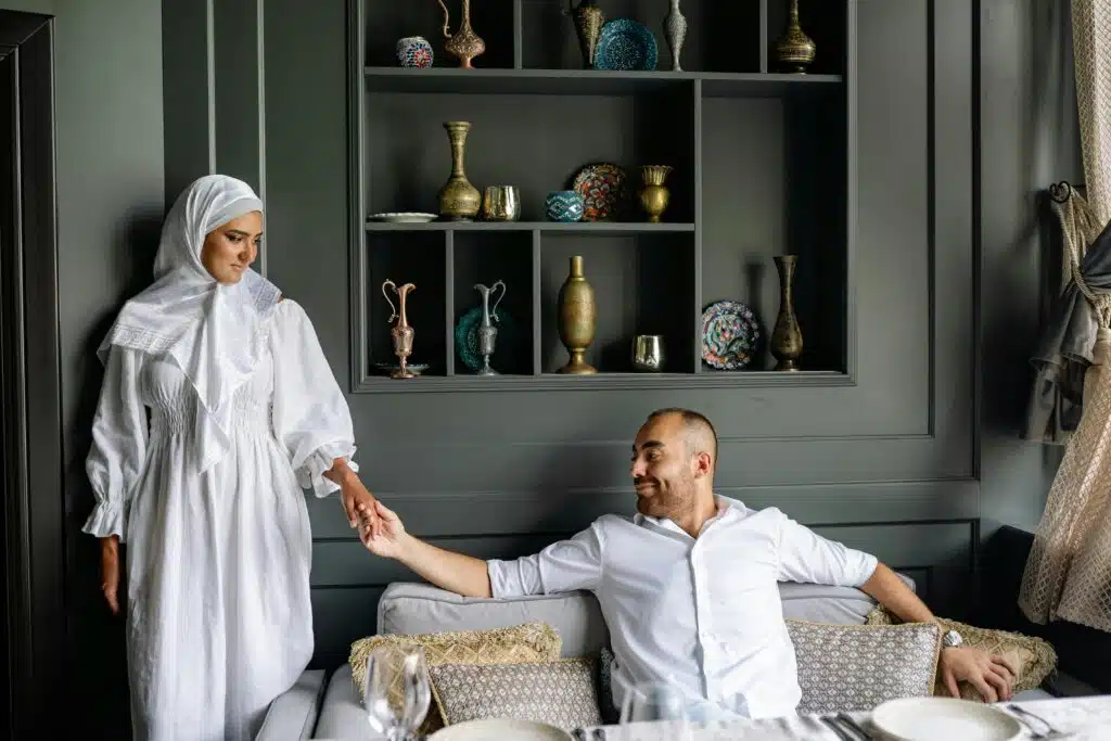 Muslim couple sharing a tender moment in a stylish living room setting.